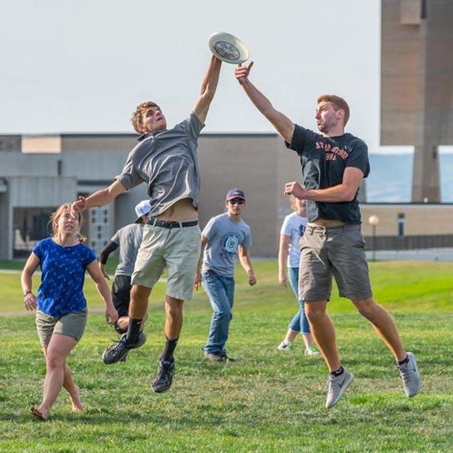 Group of students playing frisbee on the shire.